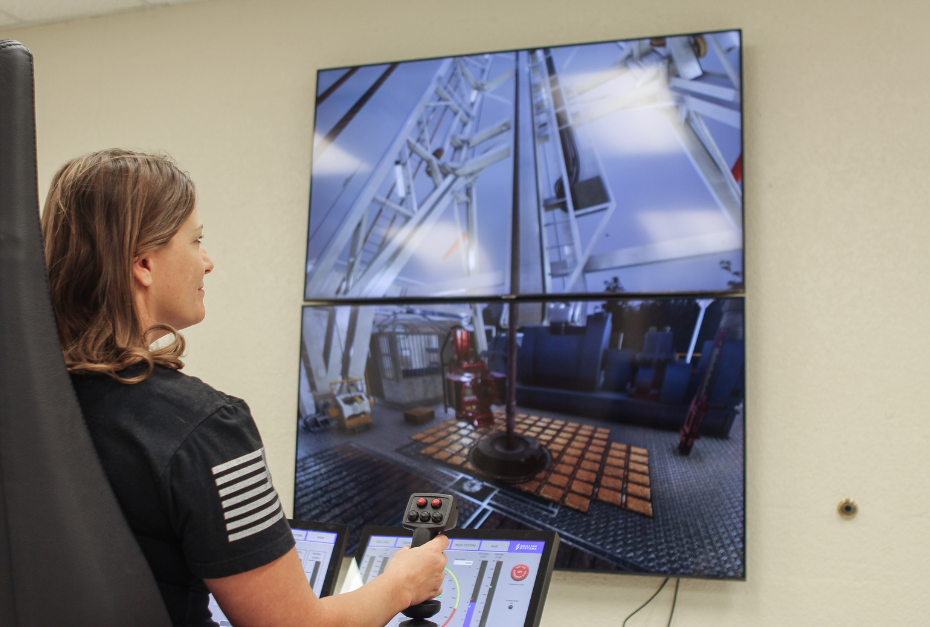 A person operates a control system with screens displaying drilling operations.