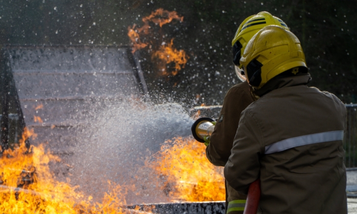 deux pompiers éteignent un incendie dans le cadre d'une formation aux interventions d'urgence