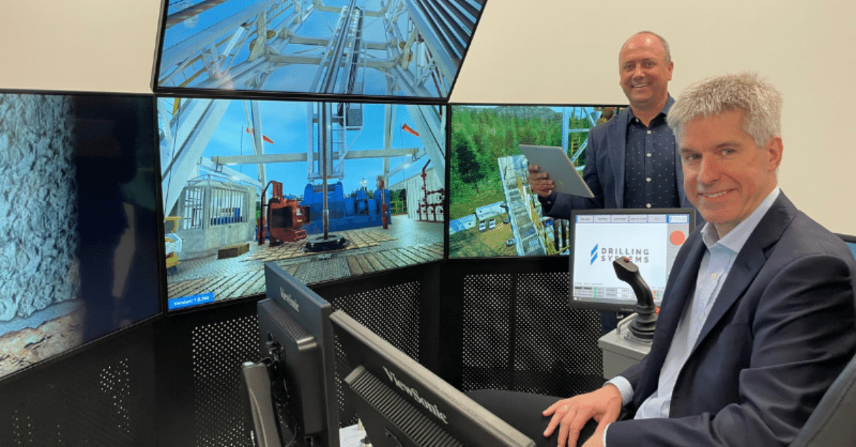 Two men in a control room with multiple monitors displaying drilling equipment and scenes. One man is seated at a control desk, while the other stands holding a tablet.