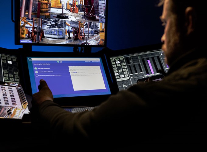 A person operates equipment using various screens, including one showing images of machinery and another displaying digital data and controls.