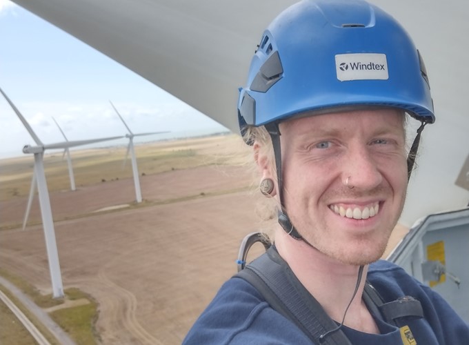 A person wearing a blue helmet labeled 