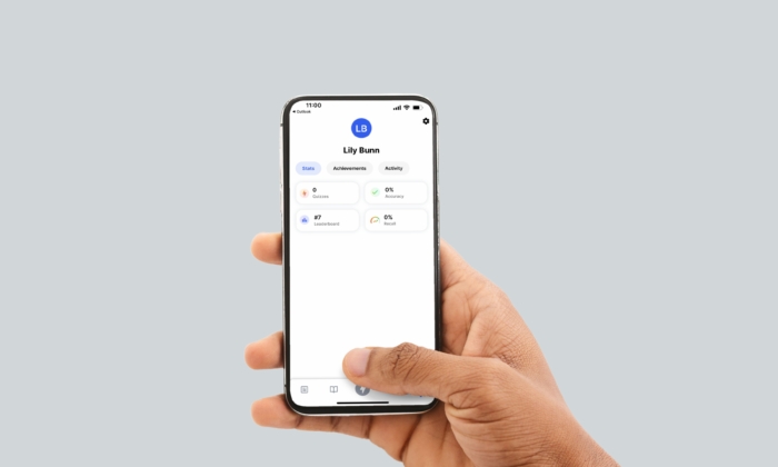 A hand holding a smartphone displaying a profile screen with the name 