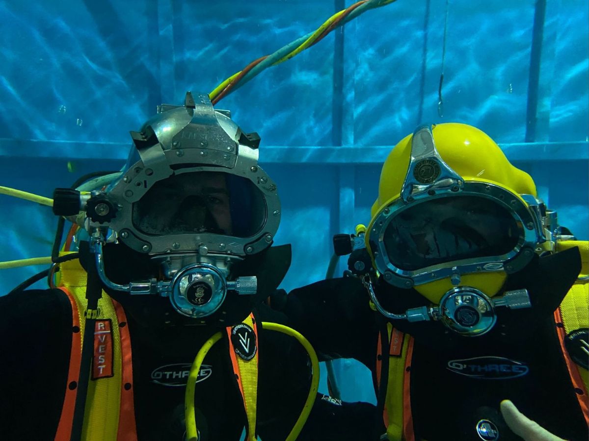 two divers underwater in helmets and breathing apparatus