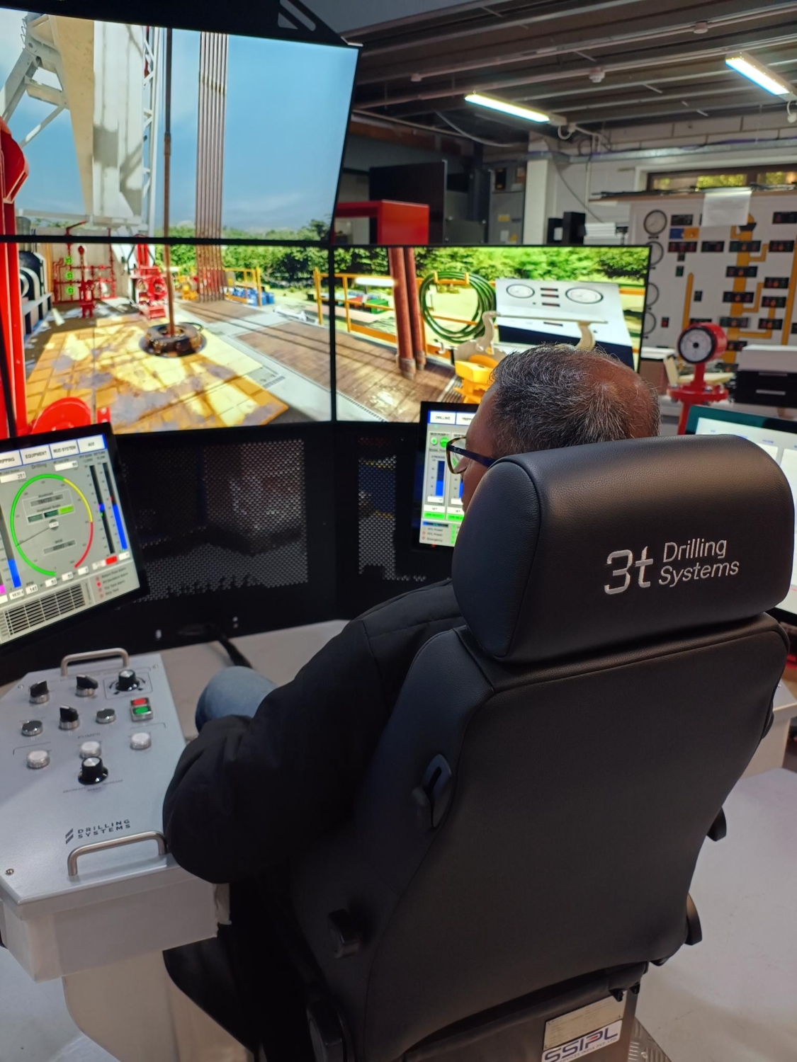 Rear view of chair with man sitting in it using drilling simulator technology
